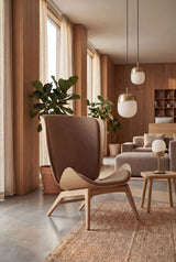 UMAGE_lifestyle_The Reader_oak_sugar brown_Paff_travertine_oak_Spring_pendant lampshade_medium_large_brass_Spring_table lamp_brass.jpeg